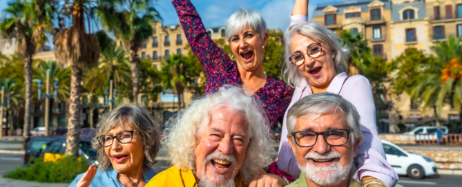 group of cheerful retired friends posing for a photo on vacation