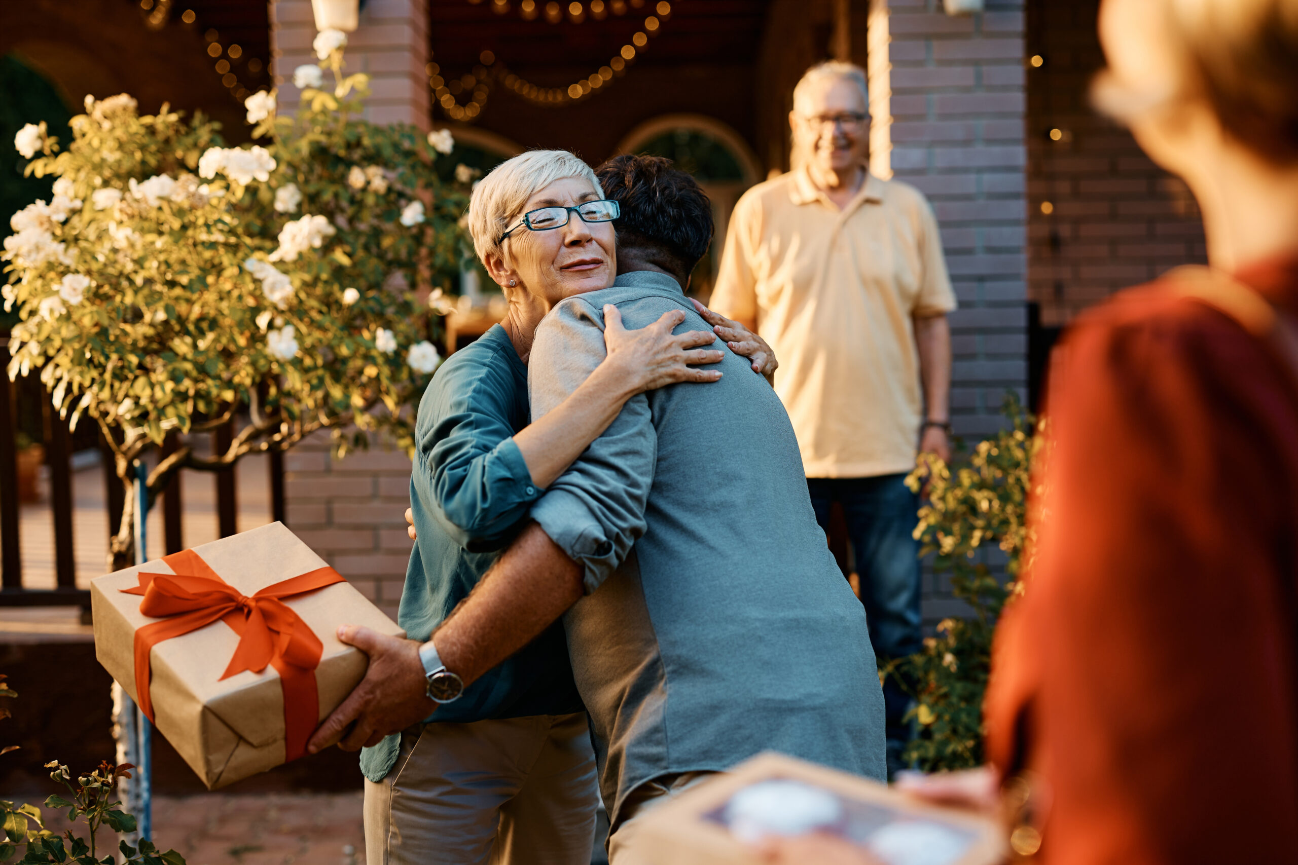 Happy senior woman embracing her son who came for a family visit.