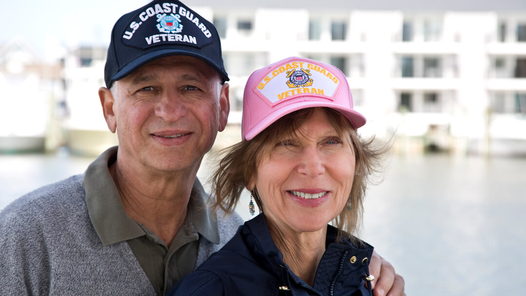 Man and woman couple wearing US Coast Guard Veteran ball caps